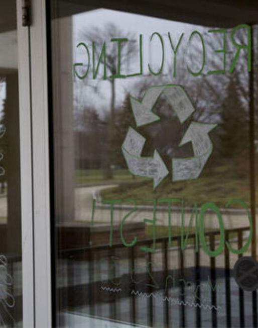 Recycling Contest is painted on a glass door, promoting a recycling contest between residence halls 